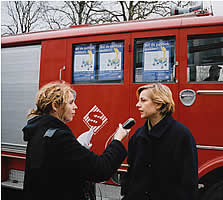 Agnes Kant wordt geinterviewd voor een rode brandweerwagen